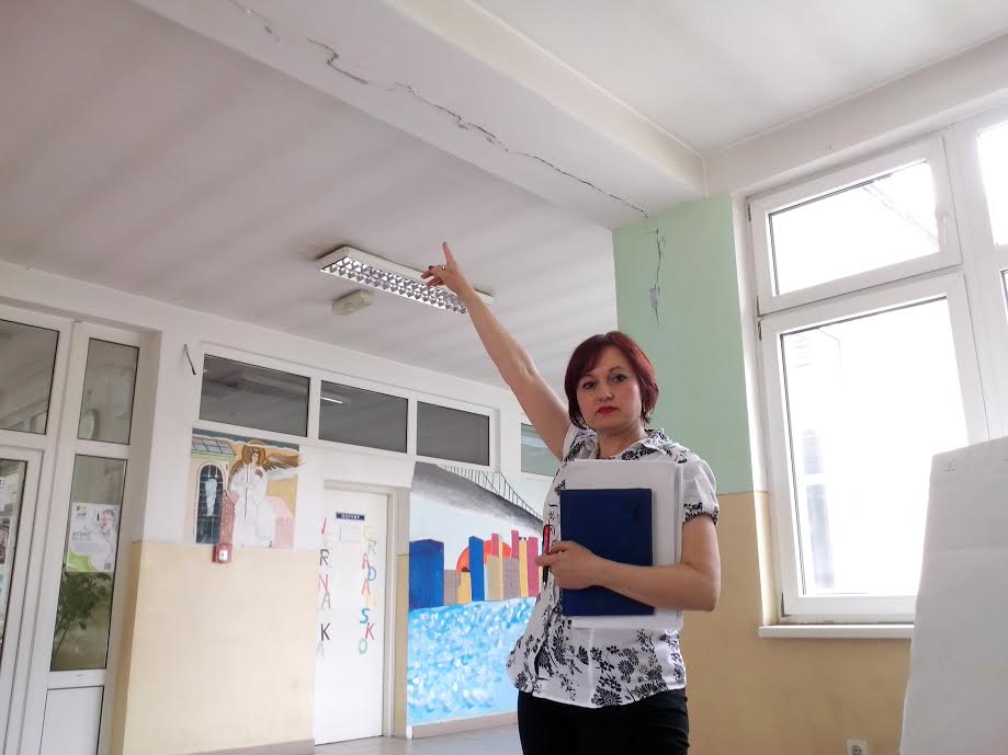 medicinska direktorka pokazuje ostecenja nastala nakon renoviranja skole