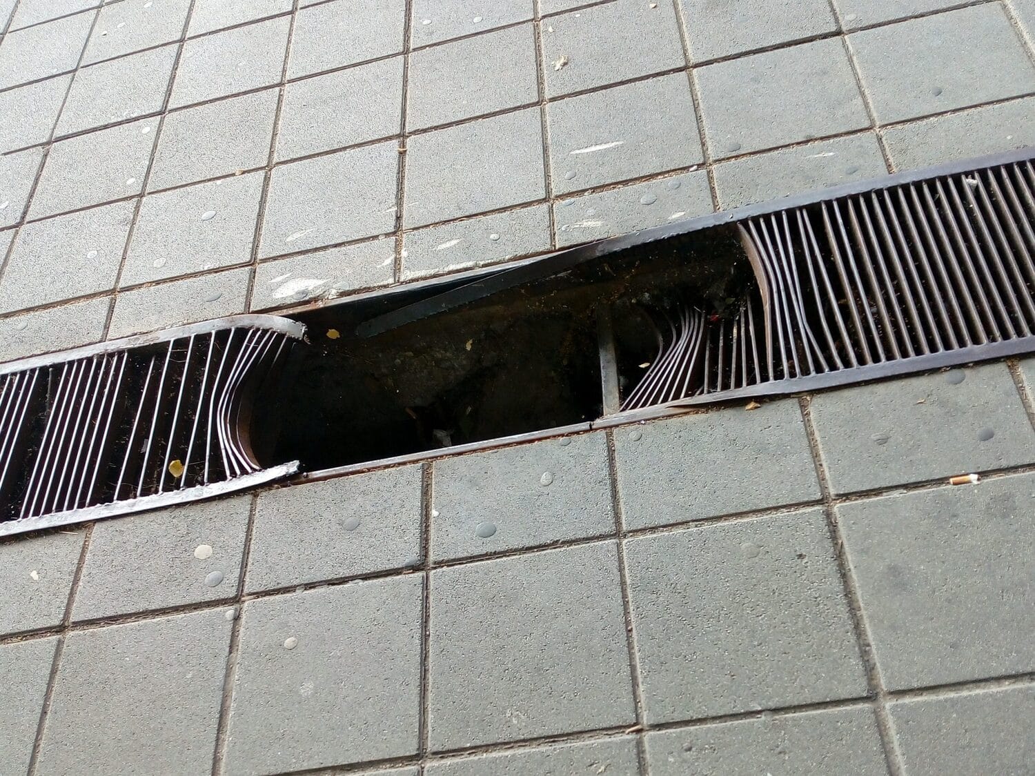 Građani se žale na cev koja stalno puca i ulicu koja je dve decenije bez svetla - iz Direkcije bez odgovora 1 Rupa u resetkastom slivniku Trg patrijarha Pavla foto citalac scaled