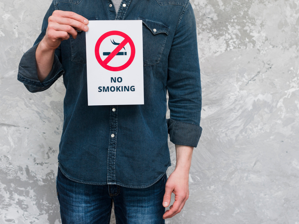 midsection man holding paper with no smoking text sign